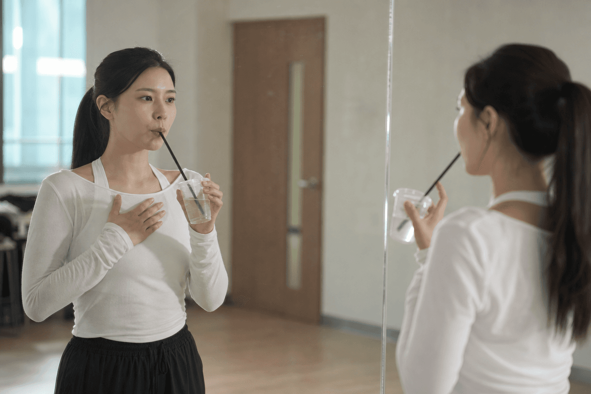 연습실에서 립트릴과 허밍, 빨대 발성으로 고음 목 갈라짐 예방 워밍업을 하는 여성 모습