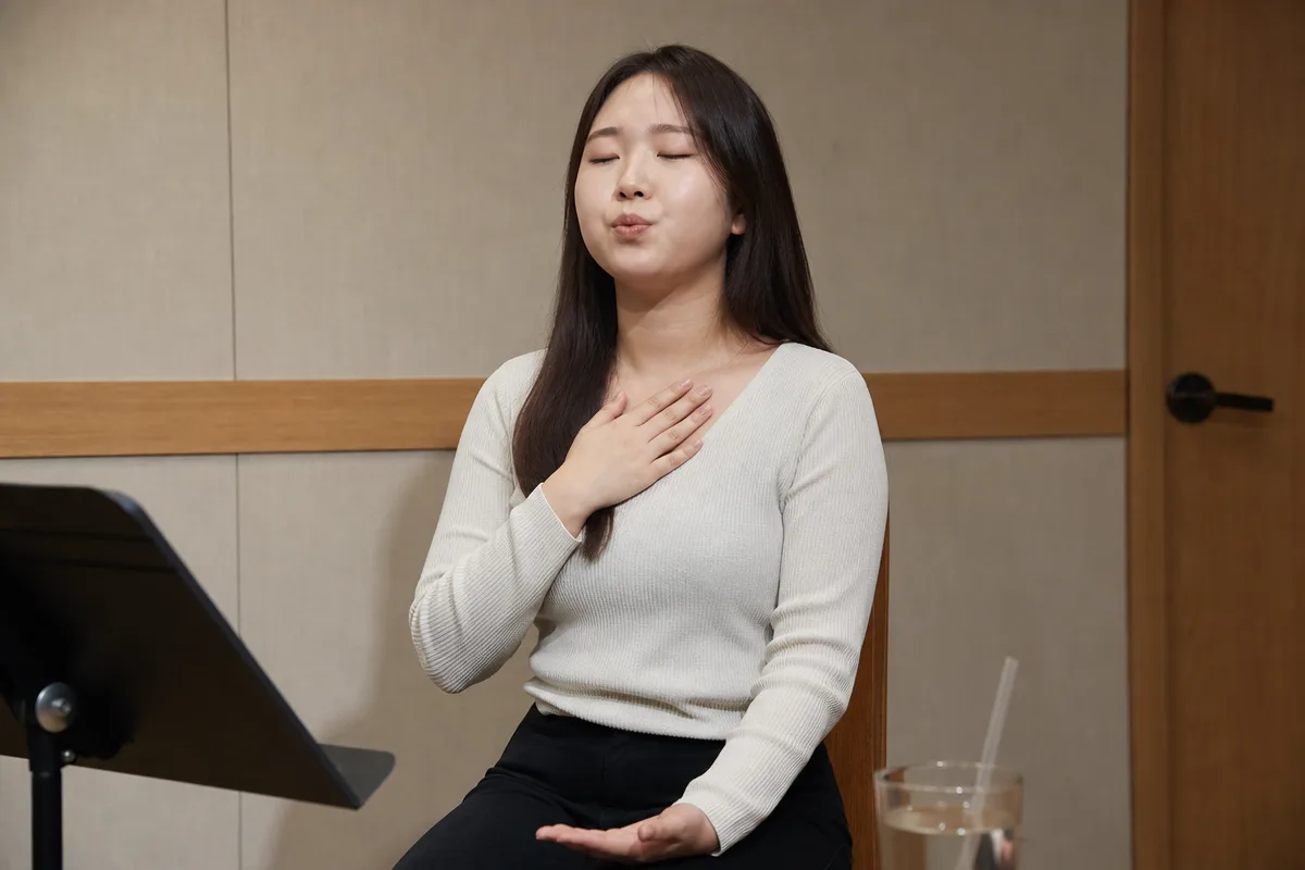 보컬 연습실에서 가슴에 손을 얹고 립트릴하는 흉성 쓰는법 훈련 모습