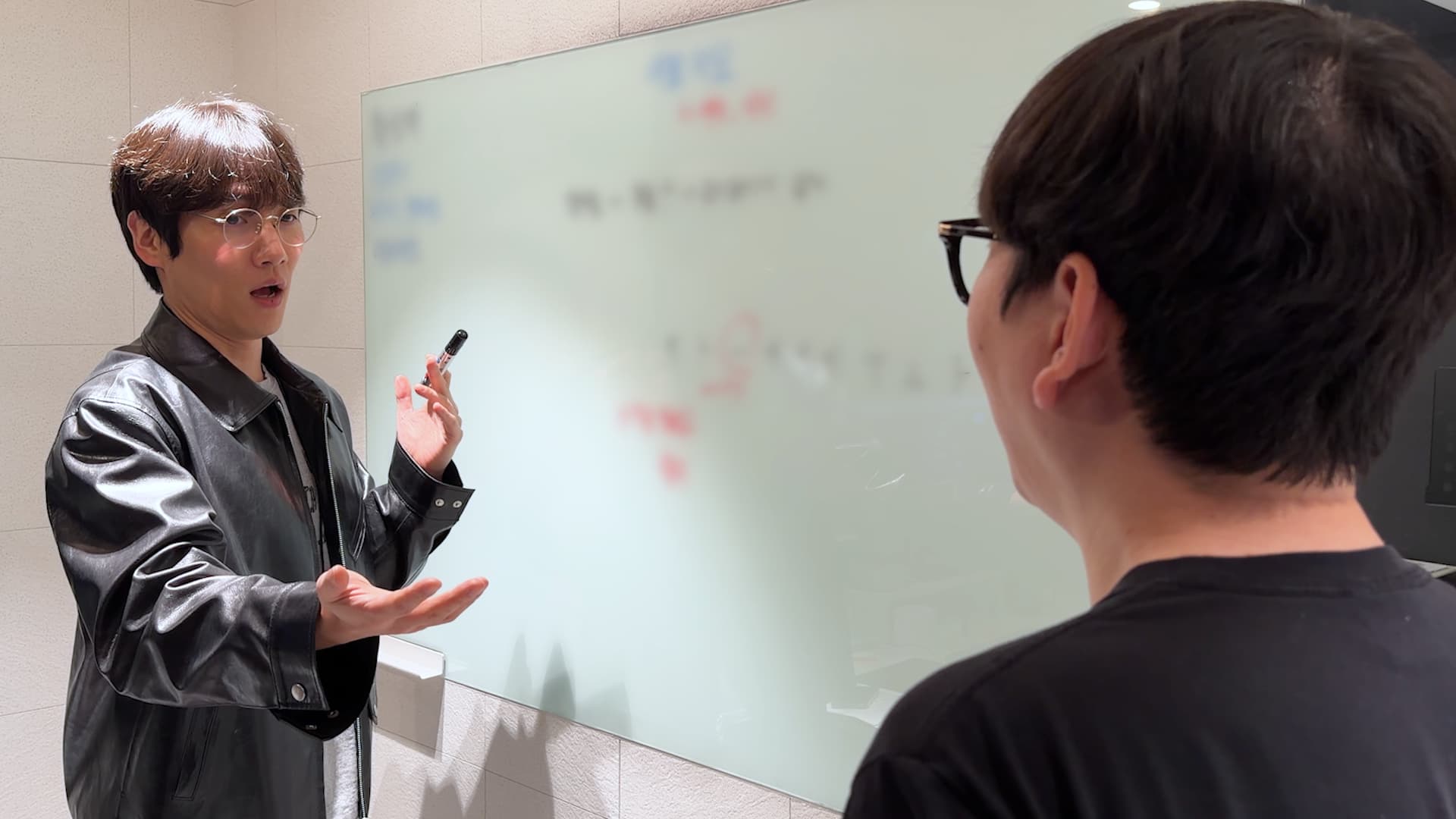 화이트보드 앞에서 설명하는 보컬 트레이너와 수강생