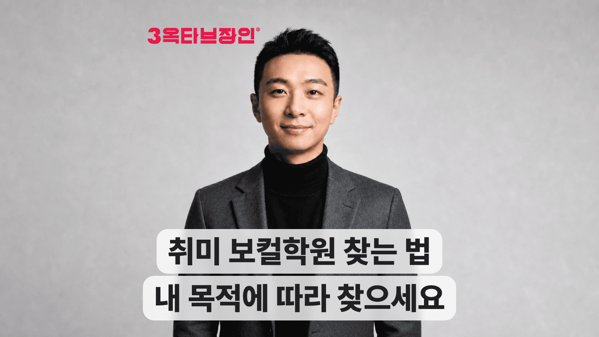 검은 터틀넥과 회색 재킷 차림의 남성이 웃으며 보컬학원 찾는 법을 안내한다.