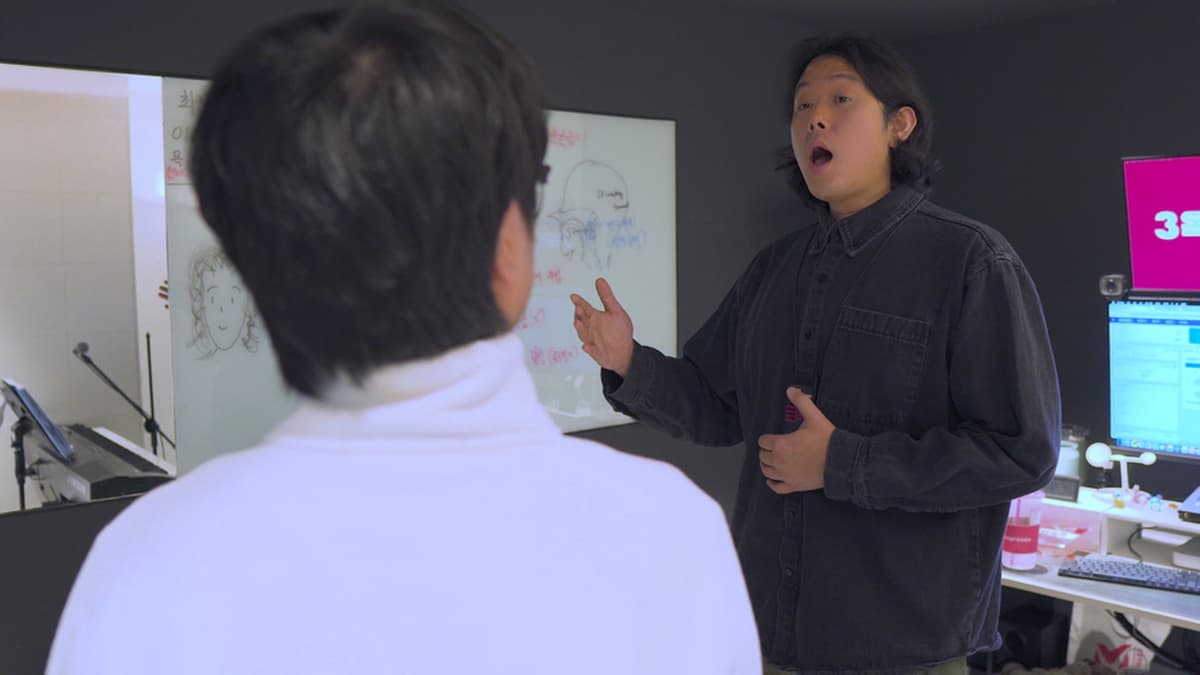 강사가 배에 손을 대고 소리를 내며 수강생에게 발성을 시범 보인다.