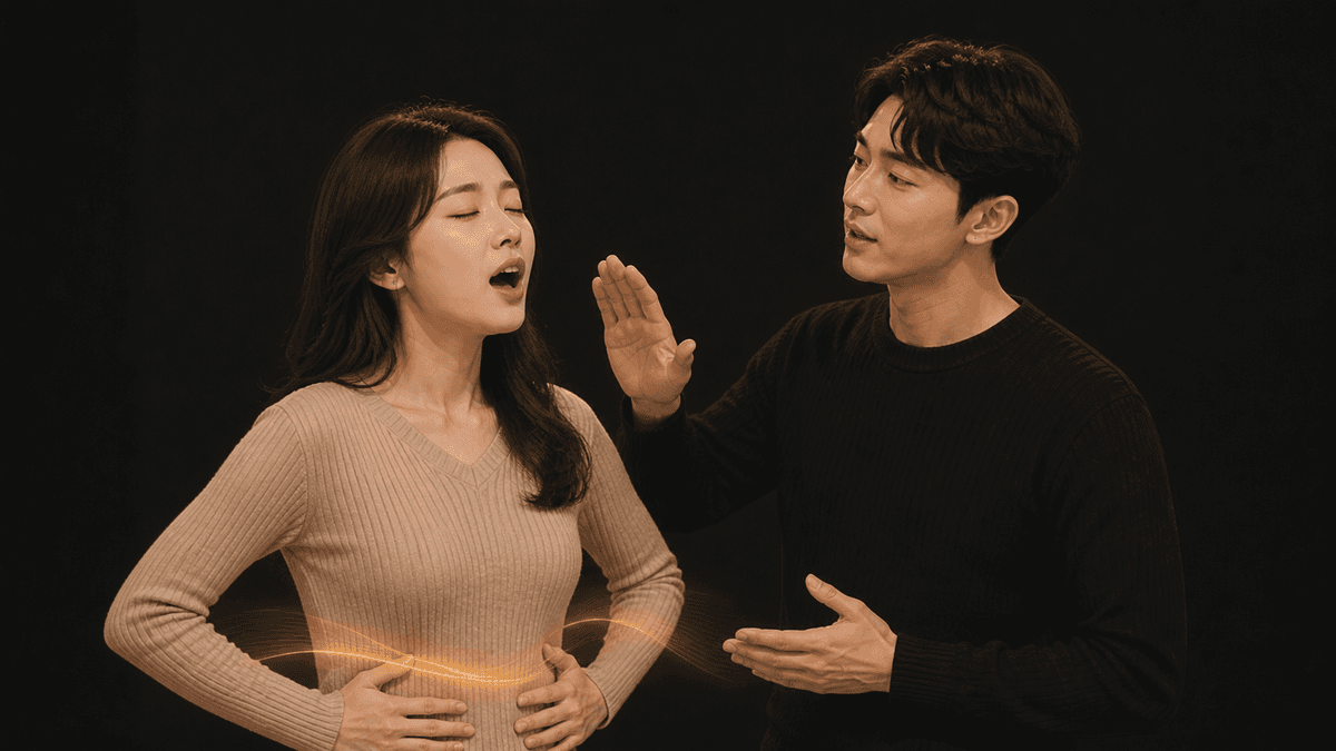 한국인 성인 수강생이 노래하며 양손을 옆구리에 대고 강사가 호흡을 안내하는 장면